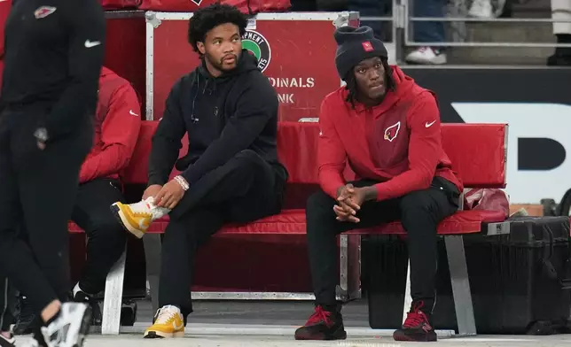 Arizona Cardinals quarterback Kyler Murray, left, and wide receiver Marvin Harrison Jr. sit on the bench during the first half of an NFL football game against the Jacksonville Jaguars Sunday, Nov. 23, 2025, in Glendale, Ariz. (AP Photo/Rick Scuteri)