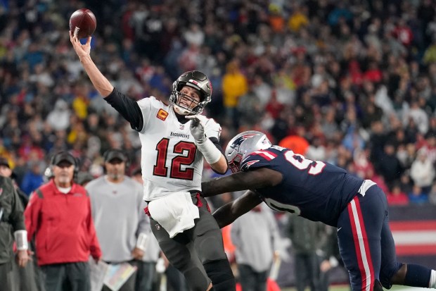 Tampa Bay Buccaneers quarterback Tom Brady (12) throws while pressured by New England Patriots defensive tackle Christian Barmore (90) during the second half of an NFL football game, Sunday, Oct. 3, 2021, in Foxborough, Mass. (AP Photo/Steven Senne)