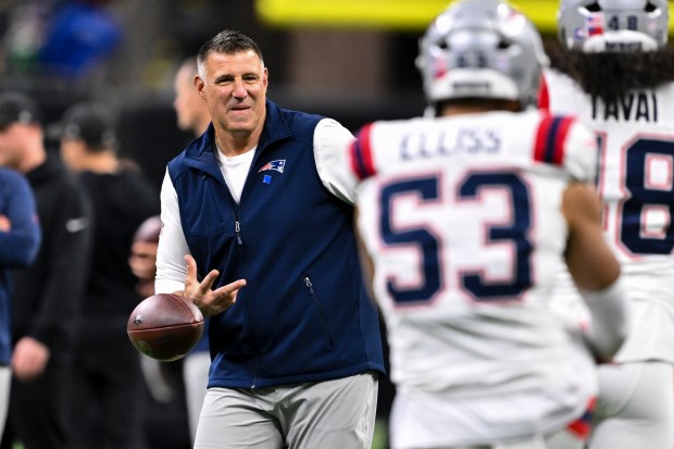 New England Patriots head coach Mike Vrabel plays catch with players prior to an NFL game against the New Orleans Saints in New Orleans. (AP Photo/Maria Lysaker)