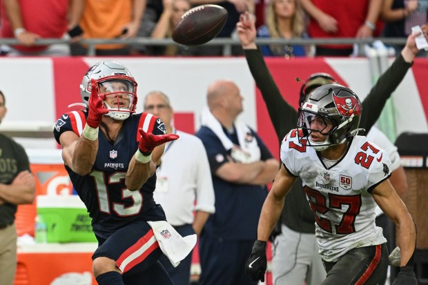 New England Patriots wide receiver Mack Hollins (13) makes a catch against Tampa Bay Buccaneers cornerback Zyon McCollum (27) during the second half of an NFL football game Sunday, Nov. 9, 2025, in Tampa, Fla. (AP Photo/Jason Behnken)