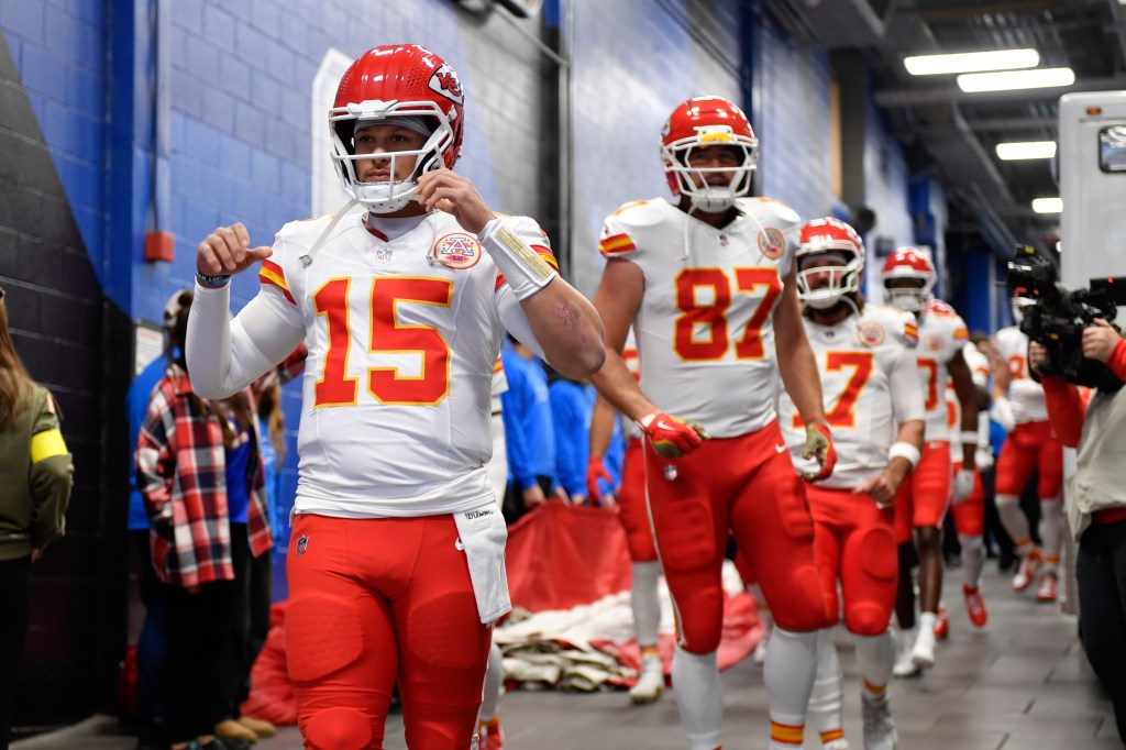 Patrick Mahomes, Travis Kelce, and other Kansas City Chiefs players walking in a hallway.
