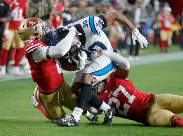 San Francisco 49ers' Malik Mustapha #6 and Ji'Ayir Brown #27 tackle Carolina Panthers' Chuba Hubbard #30 in the second quarter of their NFL game at Levi's Stadium in Santa Clara, Calif., on Monday, Nov. 24, 2025. (Jane Tyska/Bay Area News Group)