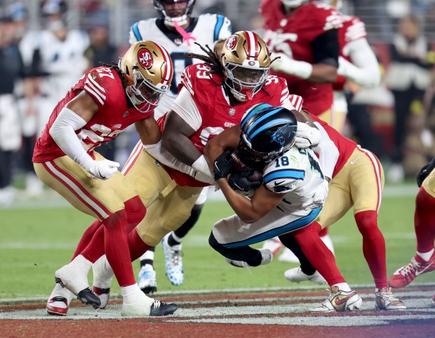San Francisco 49ers' Ji'Ayir Brown #27 and CJ West #99 tackle Carolina Panthers' Jalen Coker #18 in the fourth quarter of their NFL game at Levi's Stadium in Santa Clara, Calif., on Monday, Nov. 24, 2025. (Jane Tyska/Bay Area News Group)
