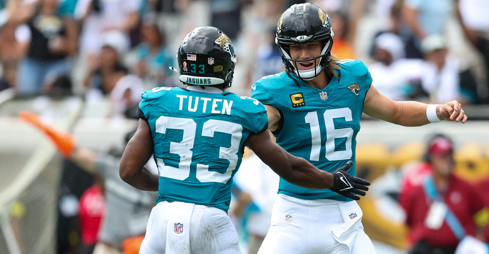 Sep 7, 2025; Jacksonville, Florida, USA; Jacksonville Jaguars running back Bhayshul Tuten (33) and quarterback Trevor Lawrence (16) celebrate a touchdown by teammate Brian Thomas Jr. against the Carolina Panthers during the first half at EverBank Stadium. Mandatory Credit: Morgan Tencza-Imagn Images
