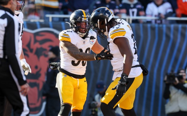 Steelers running back Jaylen Warren (30) celebrates with offensive tackle Broderick Jones after Warren scored a touchdown during the second quarter Sunday, Nov. 23, 2025, at Soldier Field. (Eileen T. Meslar/Chicago Tribune)