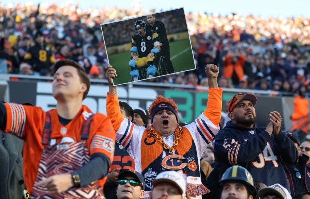 A Bears fan raises a photoshopped picture of an injured-looking Steelers quarterback Aaron Rodgers in the fourth quarter Sunday, Nov. 23, 2025, at Soldier Field. (John J. Kim/Chicago Tribune)