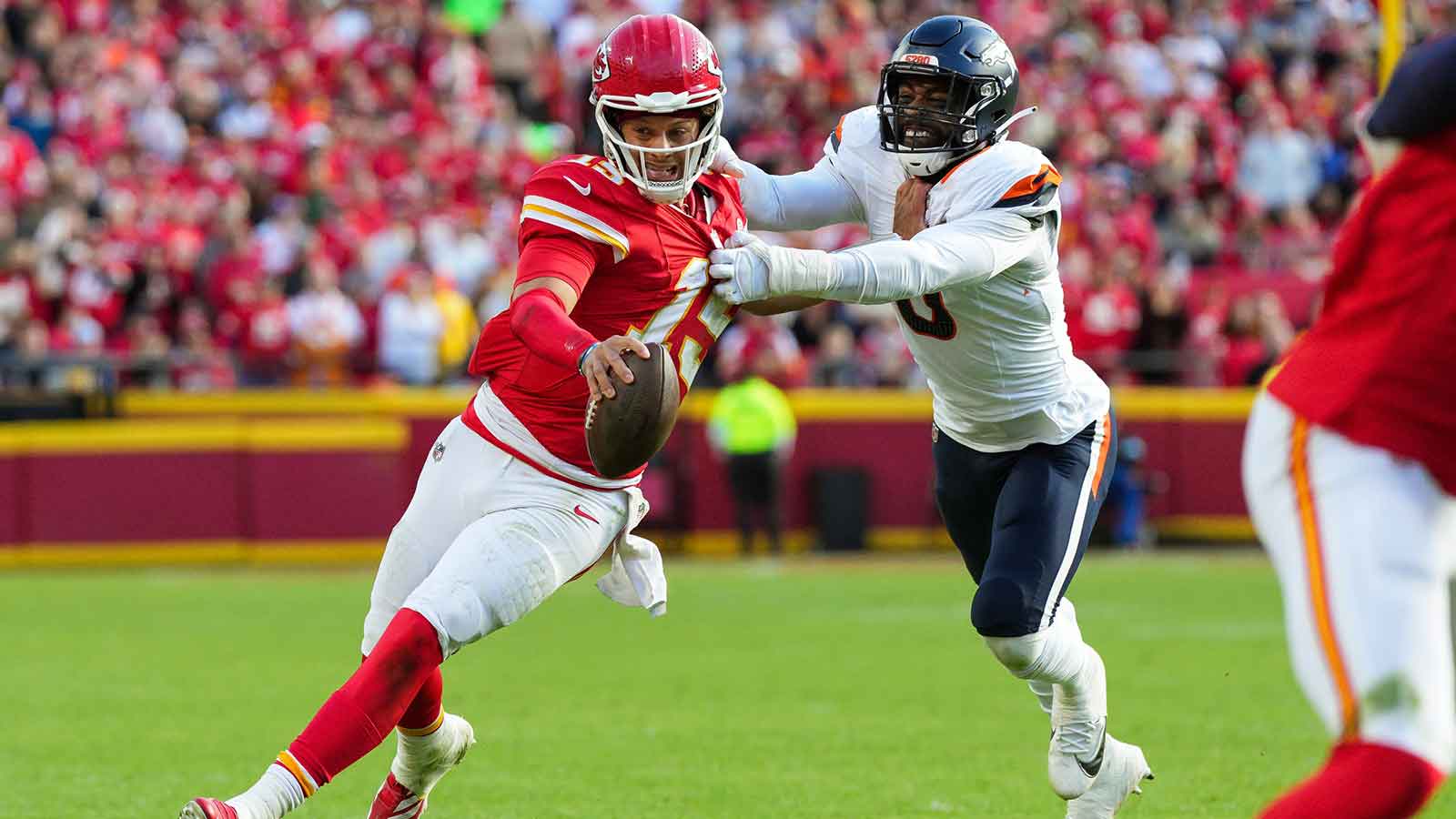 Kansas City Chiefs quarterback Patrick Mahomes (15) runs the ball against Denver Broncos linebacker Jonathon Cooper (0) during the second half at GEHA Field at Arrowhead Stadium