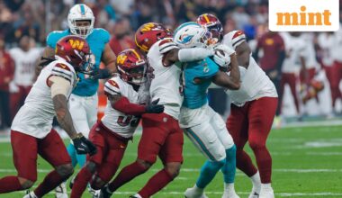 Miami Dolphins' running back #31 Ollie Gordon II (2R) is tackled during the NFL match between Miami Dolphins and Washington Commanders at Santiago Bernabeu Stadium in Madrid.