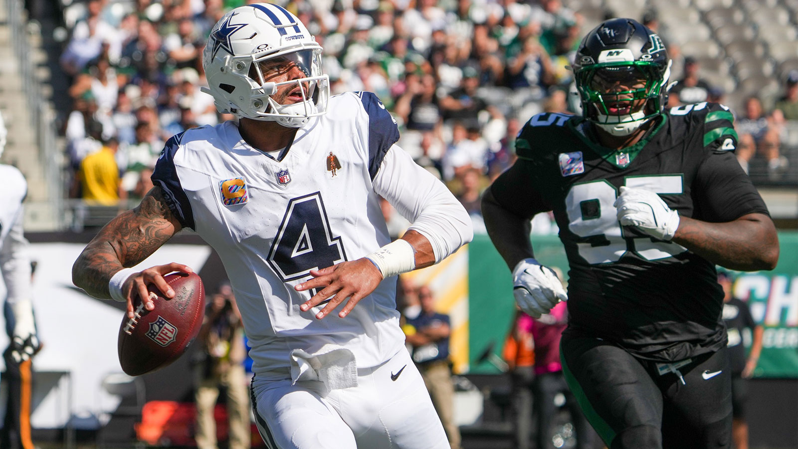 Dallas Cowboys quarterback Dak Prescott (4) looks to pass downfield as New York Jets defensive tackle Quinnen Williams (95) defends during the first half at MetLife Stadium.