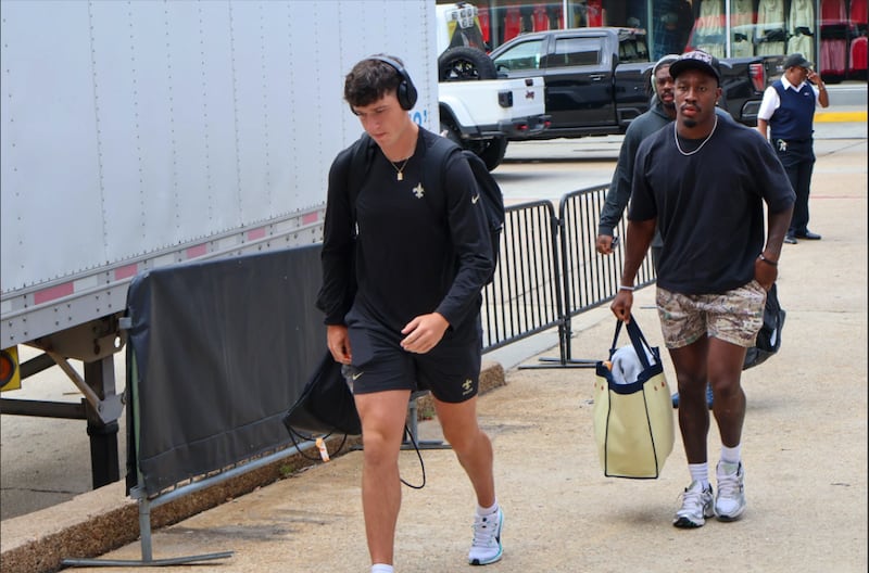 A man wearing black shorts, headphones, and a t-short walking up a ramp