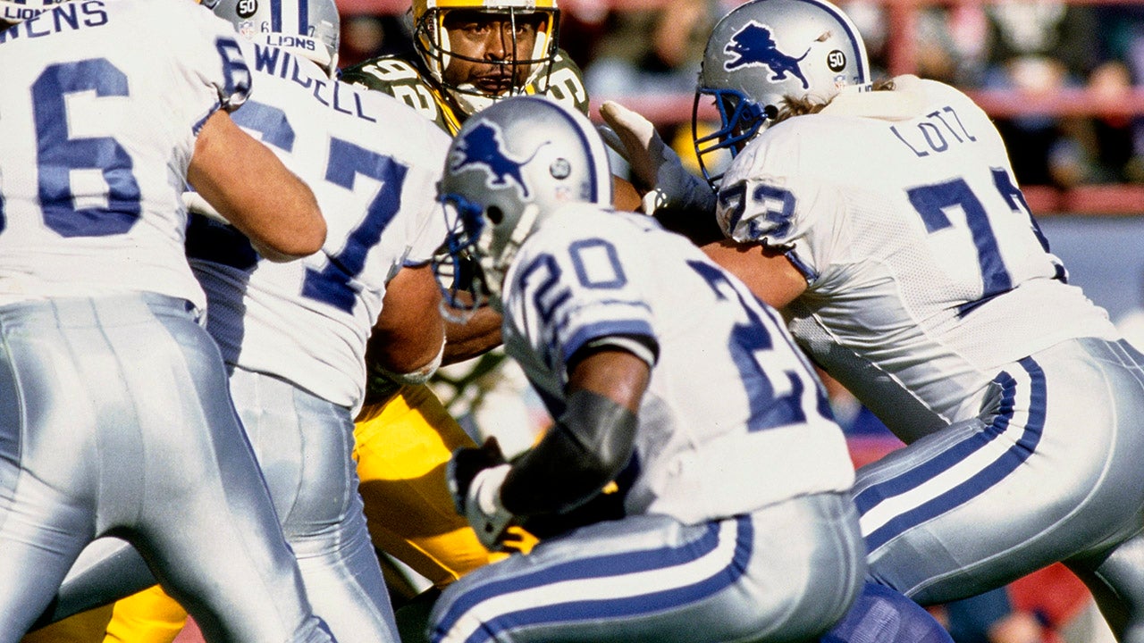 Reggie White #92, Defensive Tackle and Defensive End for the Green Bay Packers keeps his eyes on Detroit Lions Quarterback Dave Krieg (out of frame) as Running Back #20 Barry Sanders makes a play fake run. (Photo by Jonathan Daniel/Allsport/Getty Images)