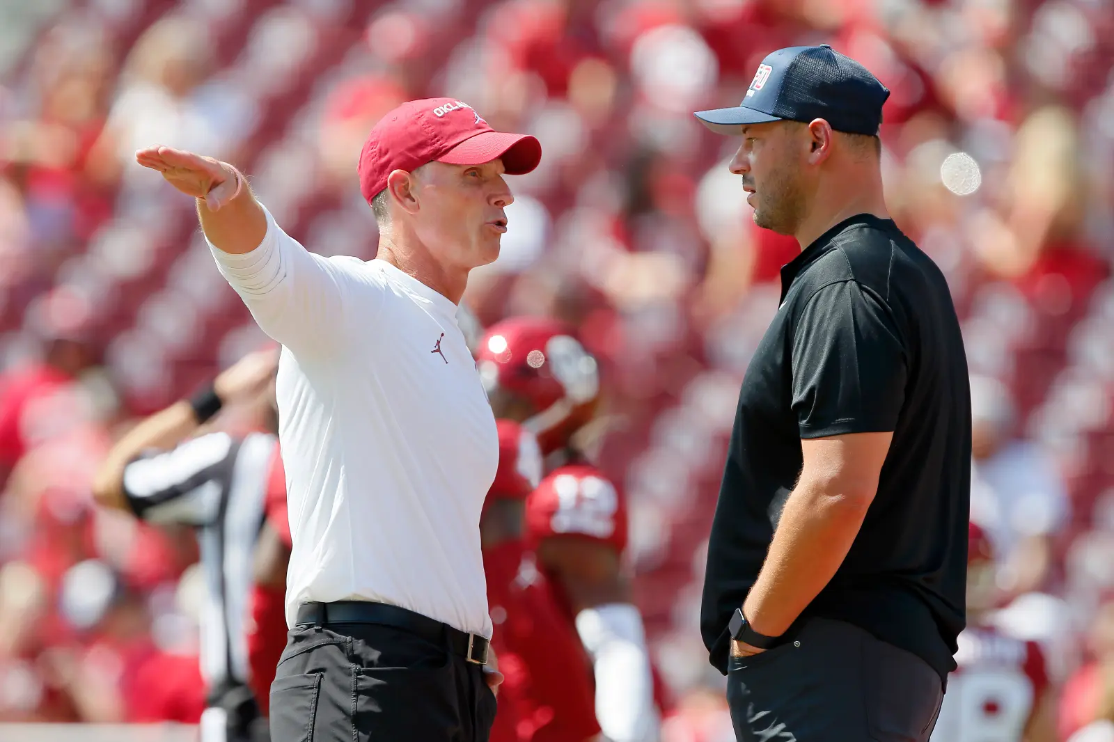 College football head coach Brent Venables of the Oklahoma Sooners talks with head coach Jon Sumrall of the Tulane Green Wave