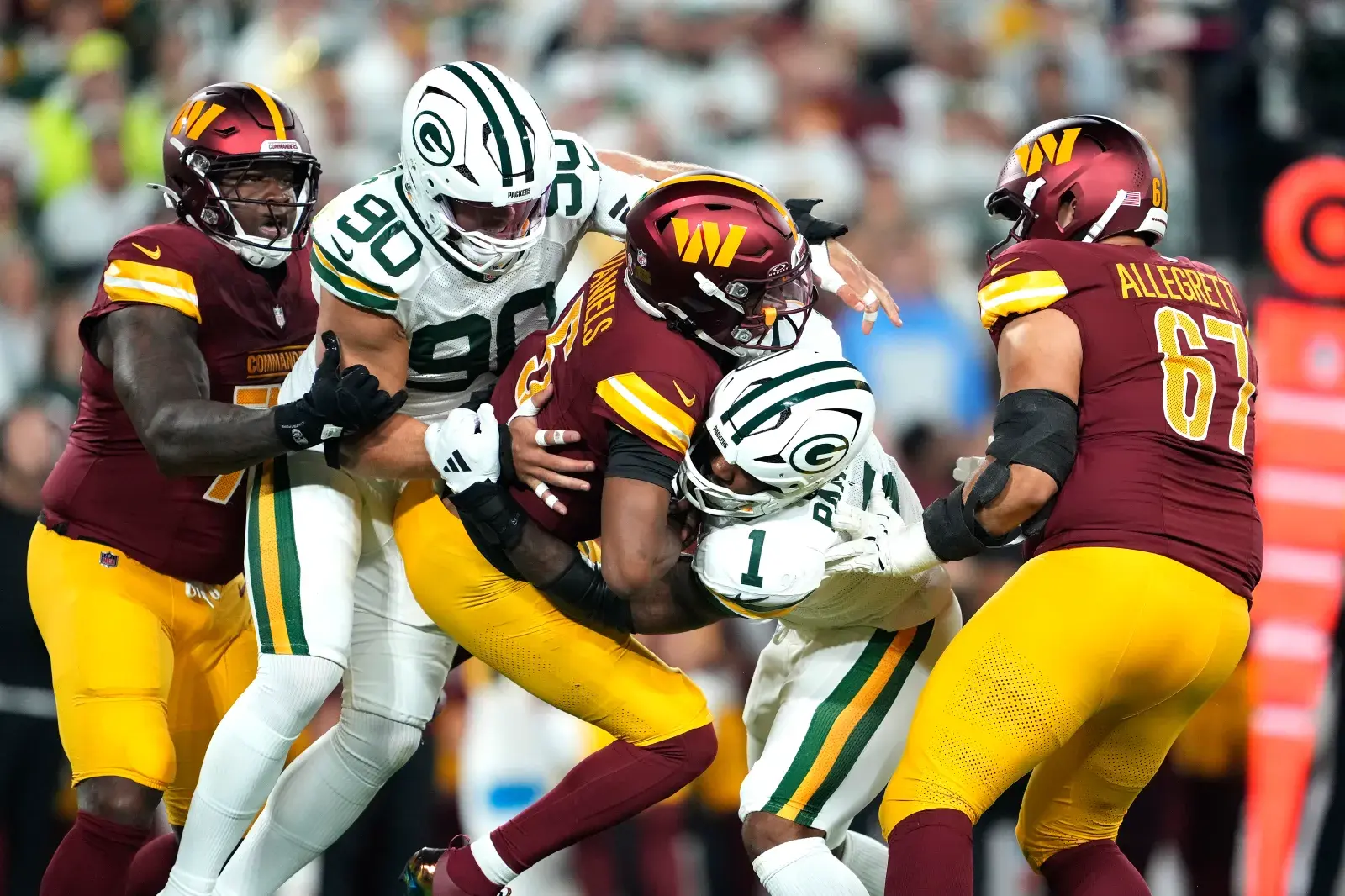 Lukas Van Ness #90 and Micah Parsons #1 of the Green Bay Packers