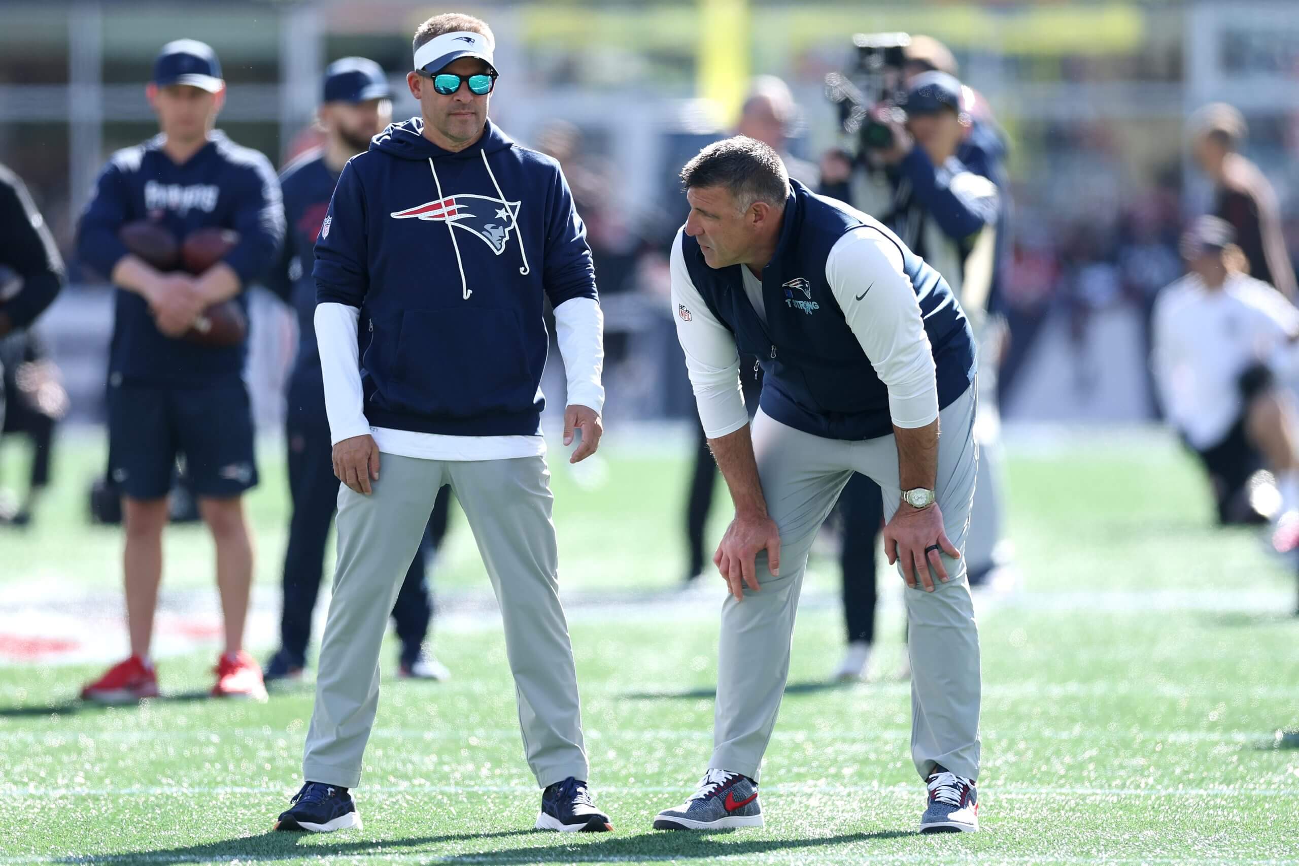 New England Patriots offensive coordinator Josh McDaniels visits with head coach Mike Vrabel before a game against the Cleveland Browns.