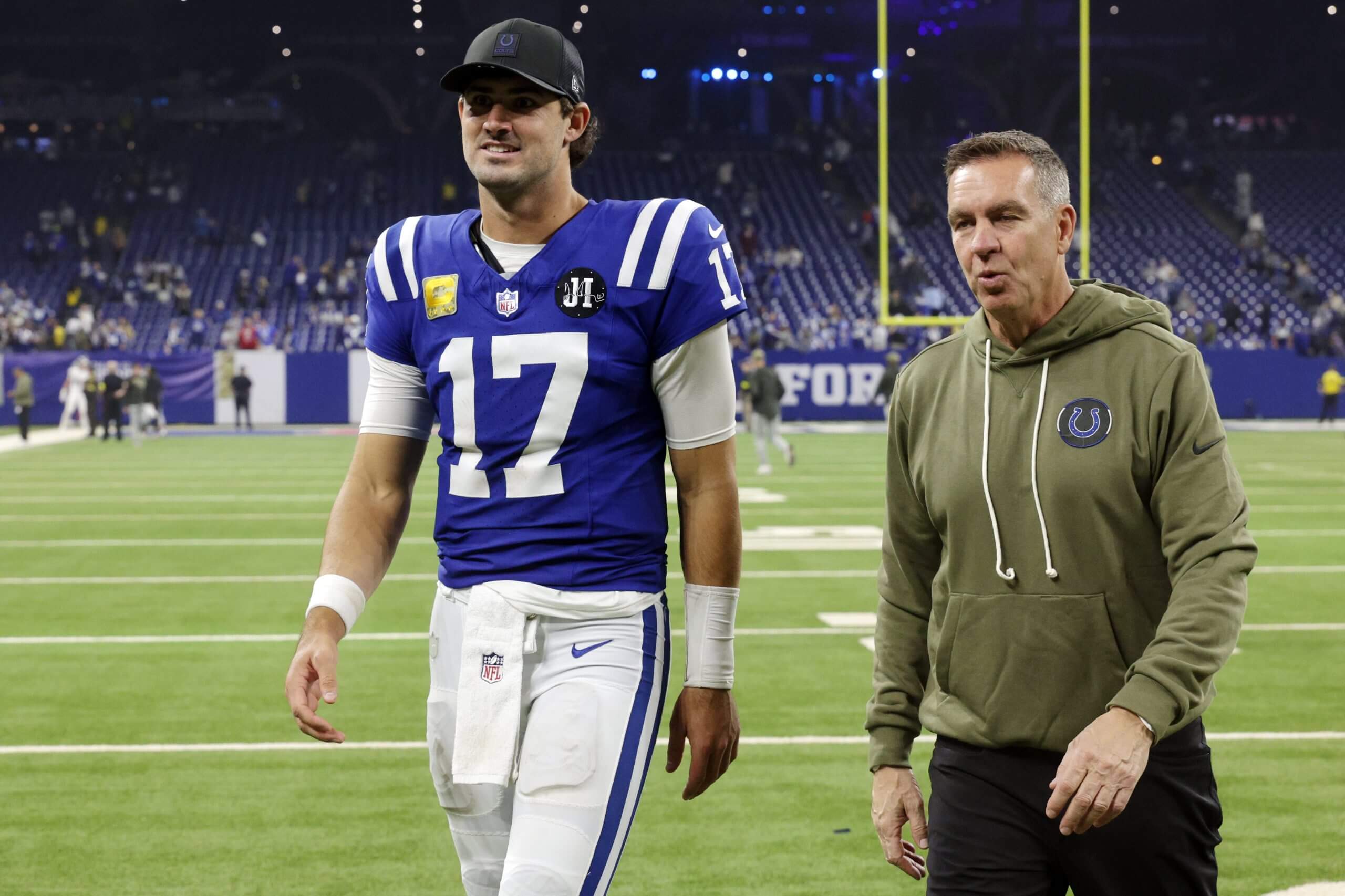 Colts QB Daniel Jones defensive coordinator Lou Anarumo walk off the field together.