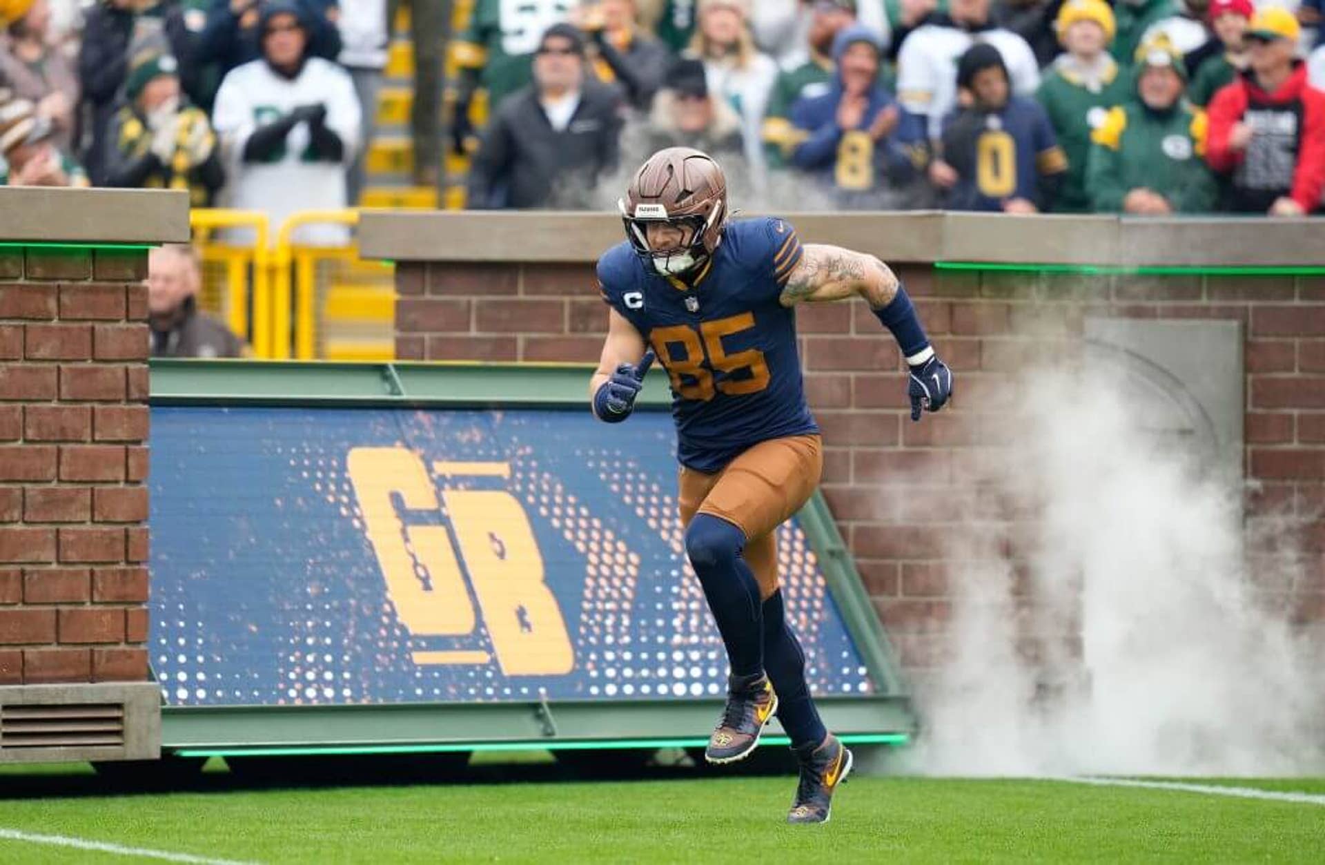 Green Bay Packers tight end Tucker Kraft, in a retro navy blue and gold No. 85 jersey, runs onto the field before Sunday's game against the Panthers.