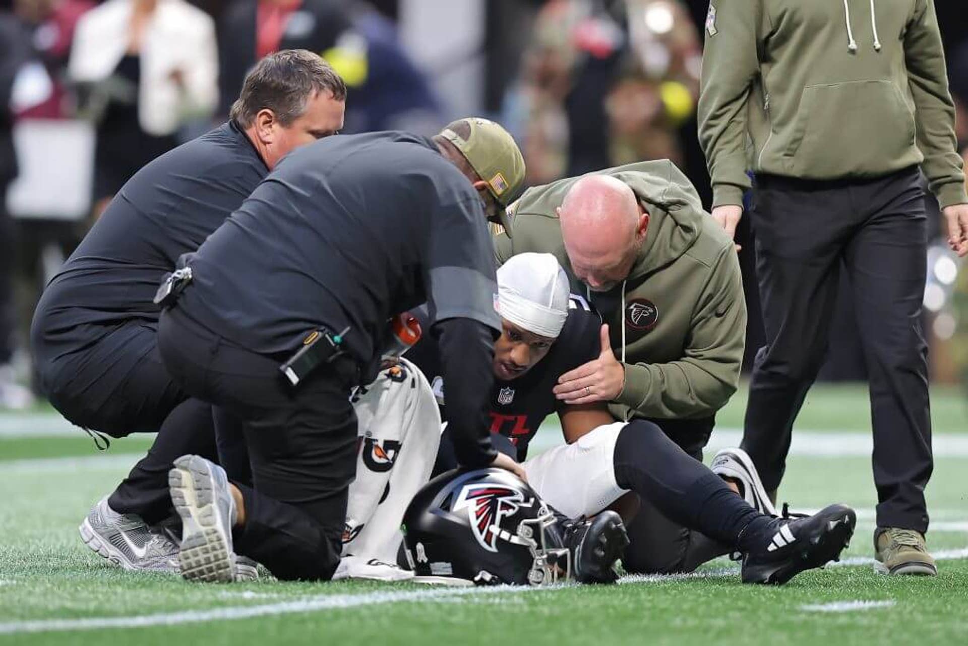 Atlanta Falcons quarterback Michael Penix Jr. is examined by medical staff on the field during an NFL game against the Carolina Panthers at Mercedes-Benz Stadium in Atlanta.