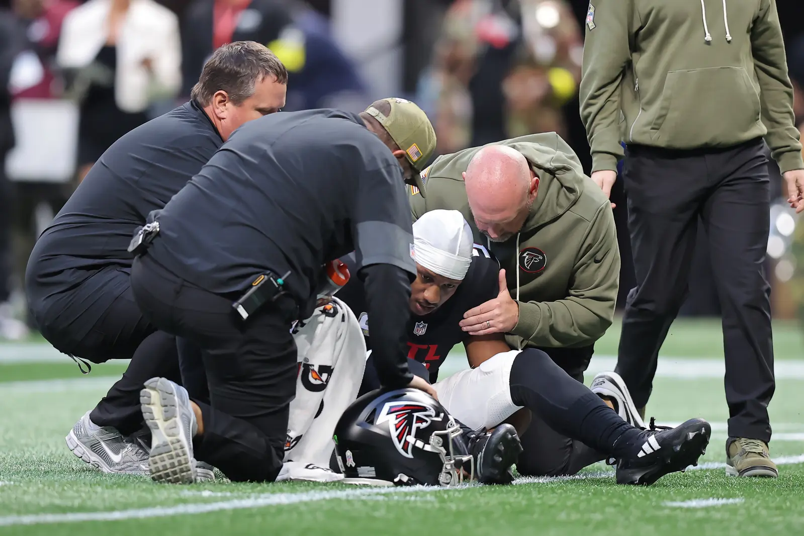 Atlanta Falcons personnel check on quarterback Michael Penix Jr during panthers game