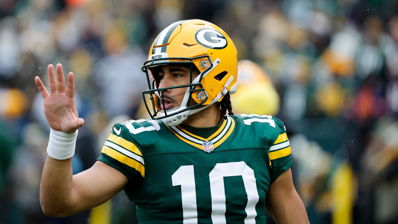 Jordan Love waving towards the crowd at a game, closeup on him.