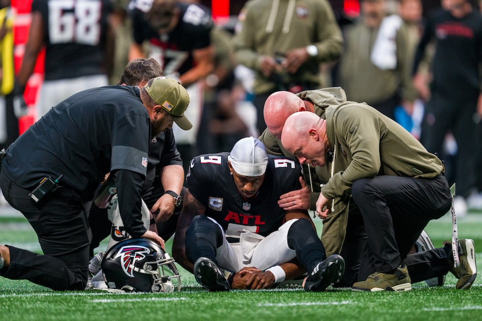 The Atlanta Falcons training staff tends to quarterback Michael Penix Jr. (9) during the...