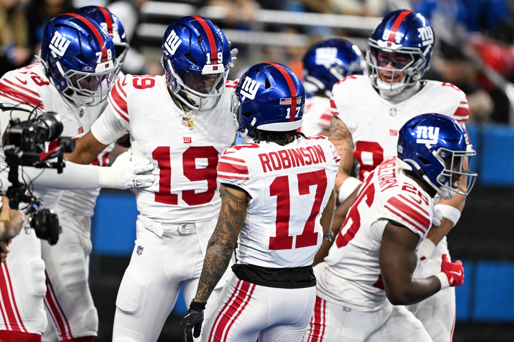 New York Giants players huddle on the field.