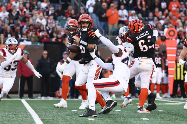 Cincinnati Bengals quarterback Joe Flacco (16) spins out of a sack attempt by New England Patriots linebacker K'Lavon Chaisson (44) during an NFL game Sunday afternoon. (AP Photo/Peter Joneleit)