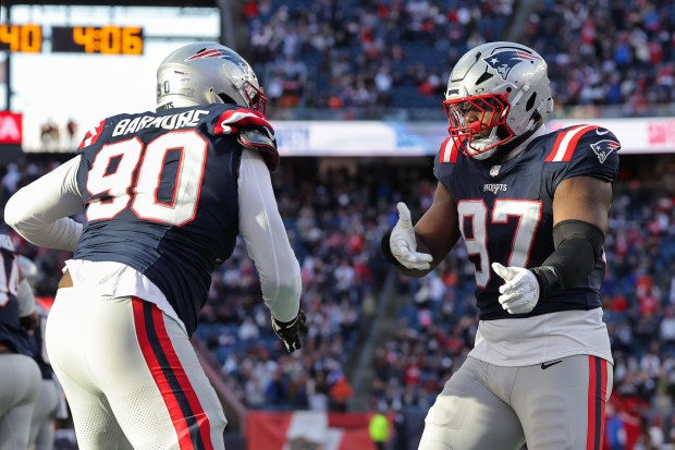 New England Patriots' Milton Williams (97) and Christian Barmore celebrate during an NFL game against the Cleveland Browns at Gillette Stadium on Oct. 26 in Foxboro. (Winslow Townson/AP Images for Panini)