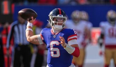 Giants quarterback Jaxson Dart readies to throw a pass with a football in hand and his arm bent back.