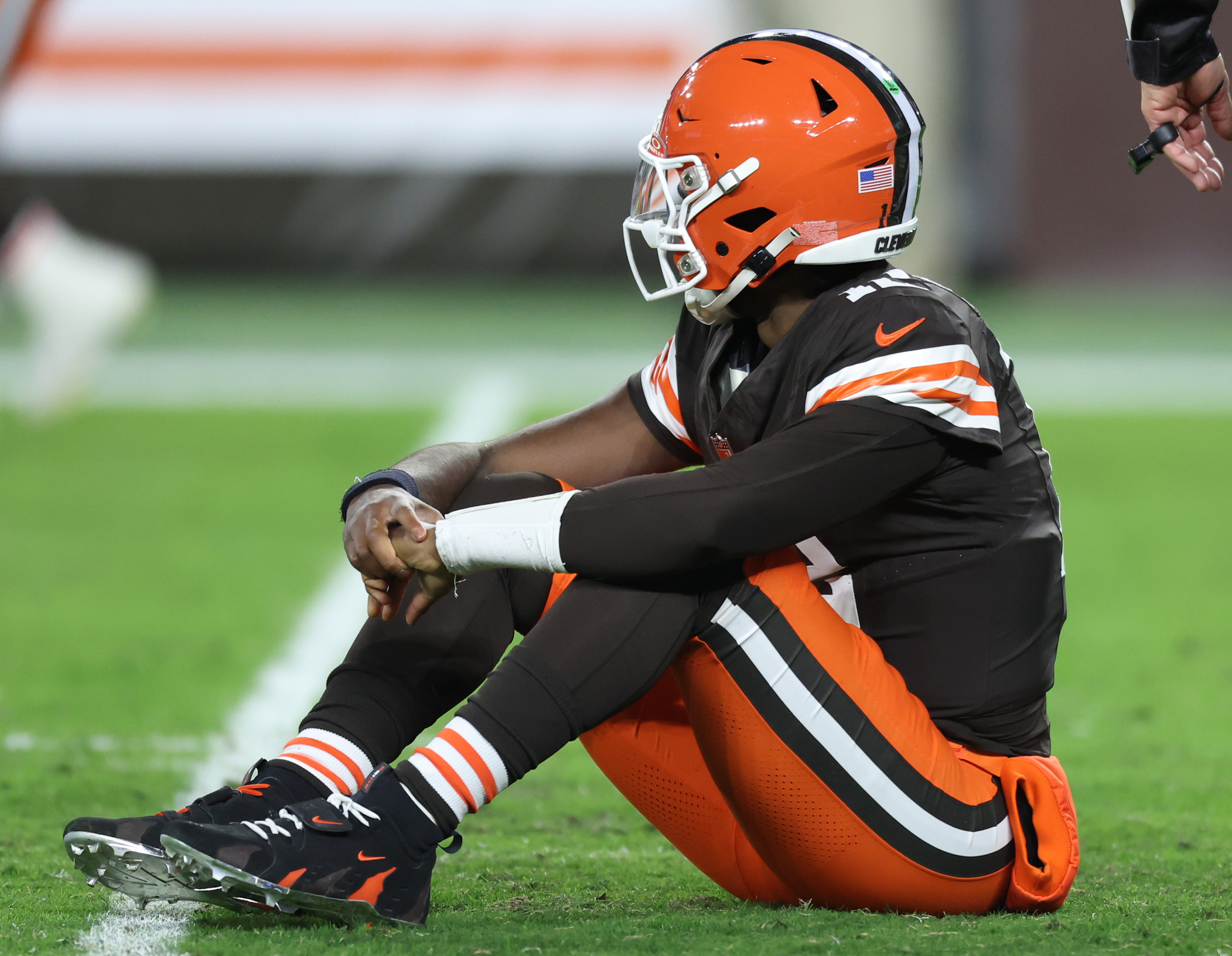 Cleveland Browns quarterback Shedeur Sanders sits on the field after throwing an interception in the third quarter.