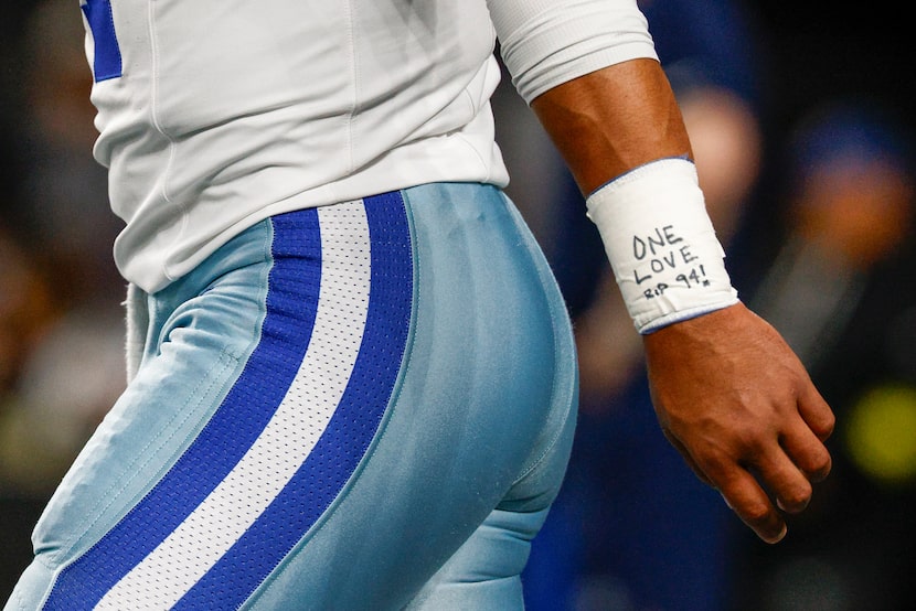 Dallas Cowboys quarterback Dak Prescott wears a message saying “ONE LOVE RIP 94” on his...