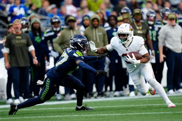 Seattle Seahawks cornerback Riq Woolen (27) lunges at Arizona Cardinals running back Emari Demercado (31) during an NFL football game, Sunday, Nov. 9, 2025 in Seattle. (AP Photo/Ben VanHouten)