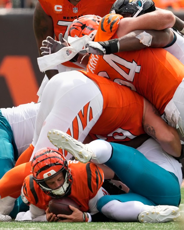 Bengals quarterback Joe Burrow, bottom, goes down with a season-ruining turf toe injury as he is sacked by Jacksonville's Arik Armstead during last Sunday's game in Cincinnati. (AP Photo/Carolyn Kaster)