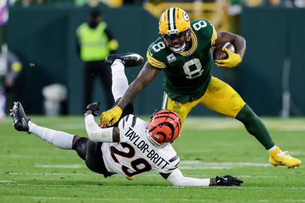Green Bay Packers running back Josh Jacobs (8) runs near Cincinnati Bengals cornerback Cam Taylor-Britt (29) in the second half of an NFL football game, Sunday, Oct. 12, 2025, in Green Bay, Wis. (AP Photo/Matt Ludtke)