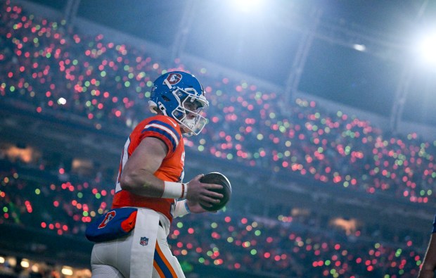 Bo Nix (10) of the Denver Broncos walks the field...