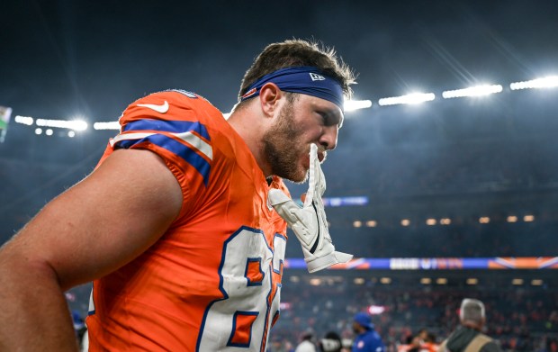 Adam Trautman (82) of the Denver Broncos chews on his...