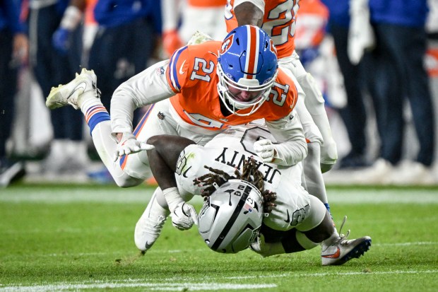 Riley Moss (21) of the Denver Broncos tackles Ashton Jeanty...