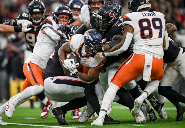 J.K. Dobbins (27) of the Denver Broncos gets swallowed up by the Houston Texans defense during the third quarter of the Broncos' 18-15 win at NRG Stadium in Houston, Texas on Sunday, Nov. 2, 2025. (Photo by AAron Ontiveroz/The Denver Post)