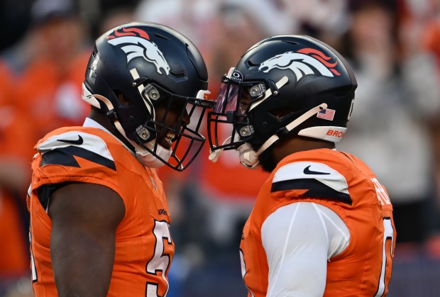 Que Robinson (51) of the Denver Broncos and Jonathon Cooper (0), right, celebrate sacking Patrick Mahomes (15) of the Kansas City Chiefs at Empower Field at Mile High on Nov. 16, 2025. (Photo by RJ Sangosti/The Denver Post)