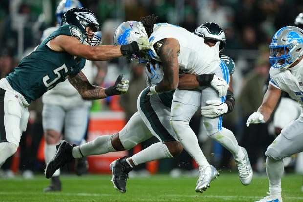 Eagles linebackers Zack Baun, left, and Jihaad Campbell (30) bring down Detroit Lions' Jahmyr Gibbs (0) during the second half on Sunday, Nov. 16, 2025, in Philadelphia. (AP Photo/Matt Rourke)