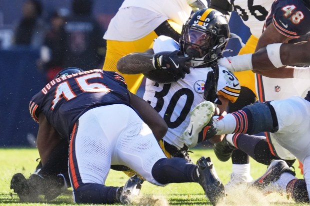 Pittsburgh Steelers running back Jaylen Warren (30) is tackled by Chicago Bears linebacker Amen Ogbongbemiga (45) during the first half of an NFL football game Sunday, Nov. 23, 2025, in Chicago. (AP Photo/Nam Huh)