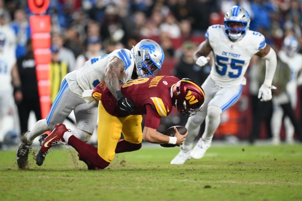 Washington Commanders quarterback Marcus Mariota (8) is sacked by Detroit...