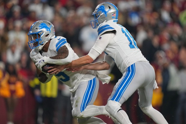 Detroit Lions quarterback Jared Goff hands off to running back...