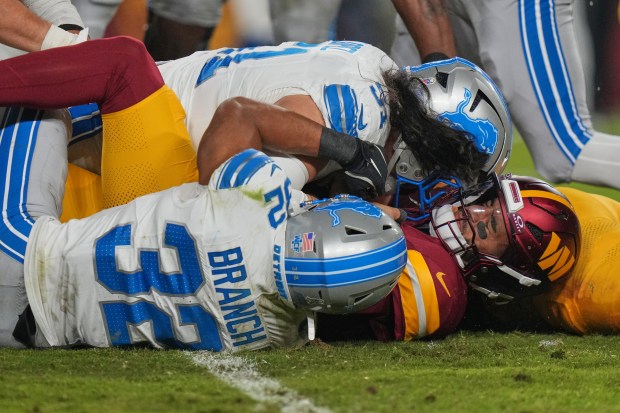 Detroit Lions defensive lineman Roy Lopez, top, and defensive back...