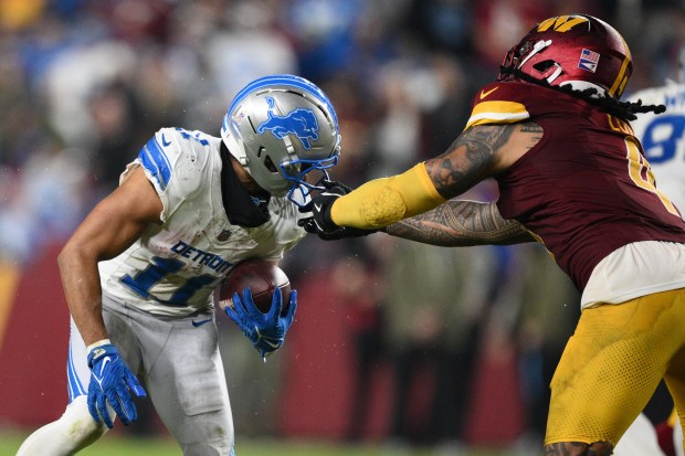 Washington Commanders linebacker Frankie Luvu (4) grabs Detroit Lions wide...