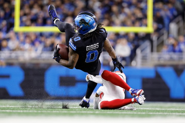 Detroit Lions running back Jahmyr Gibbs (0) is upended by...