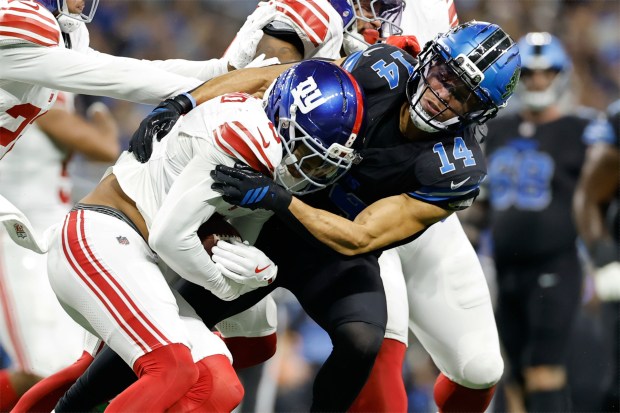 New York Giants safety Jevon Holland, left, intercepts a pass...