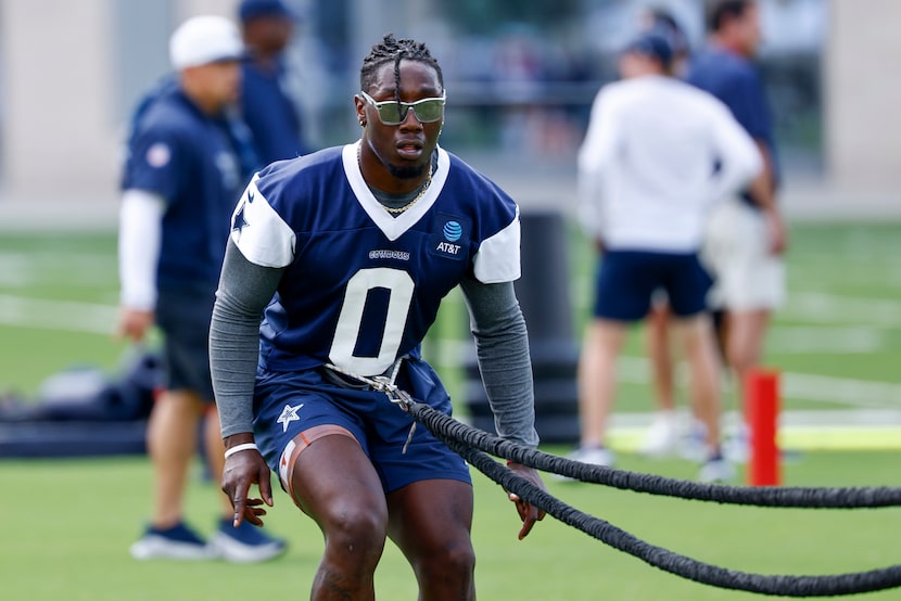 Dallas Cowboys linebacker DeMarvion Overshown works in the endzone with a trainer during...