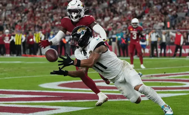 Jacksonville Jaguars wide receiver Parker Washington (11) catches a pass for a touchdown during the second half of an NFL football game against the Arizona Cardinals Sunday, Nov. 23, 2025, in Glendale, Ariz. (AP Photo/Rick Scuteri)