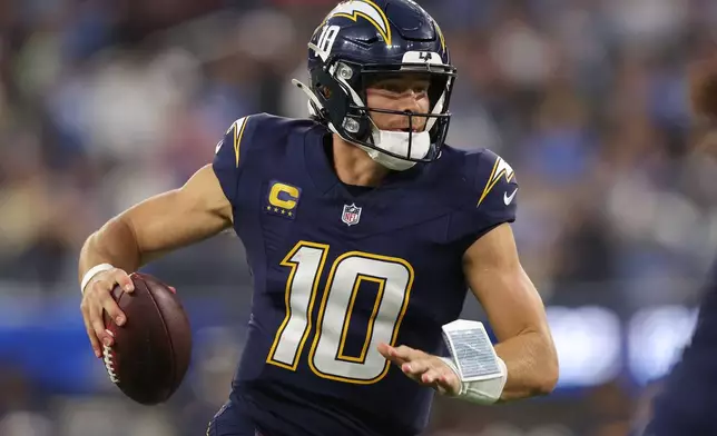Los Angeles Chargers quarterback Justin Herbert (10) runs with the football during the first half of an NFL football game against the Minnesota Vikings Thursday, Oct. 23, 2025, in Inglewood, Calif. (AP Photo/Jessie Alcheh)