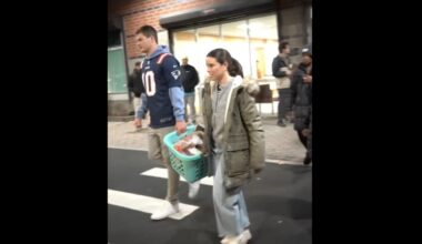 Drake Maye and his wife, Ann Michael, carrying donation baskets during a Patriots Thanksgiving charity event